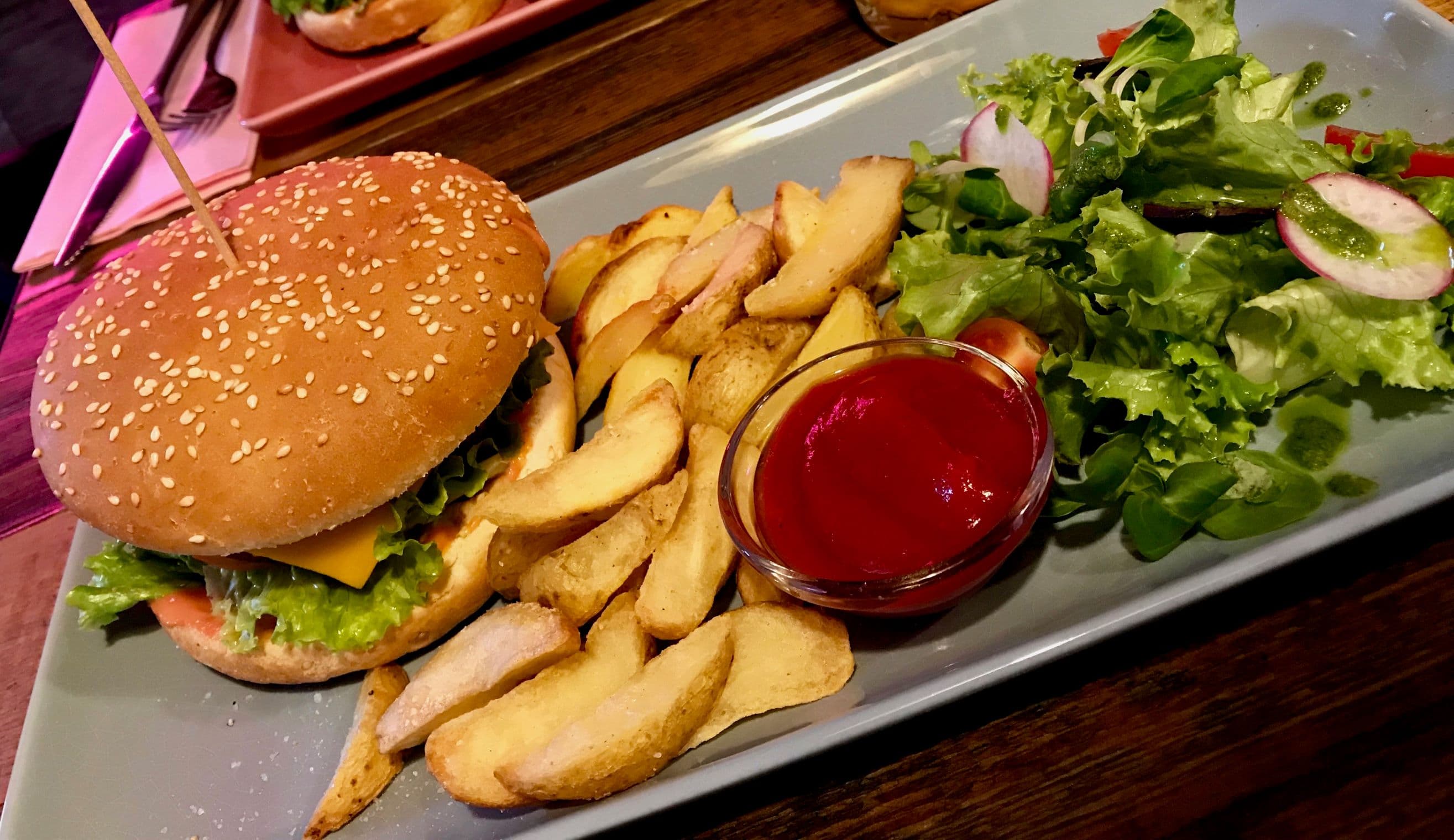 A vegan burger with fries and salad in Vilnius